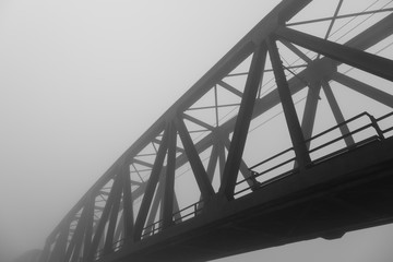 old iron bridge over wrapped in a mysterious fog