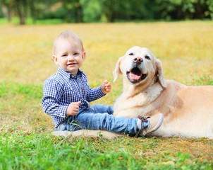 Happy smiling little boy child and Golden Retriever dog sitting