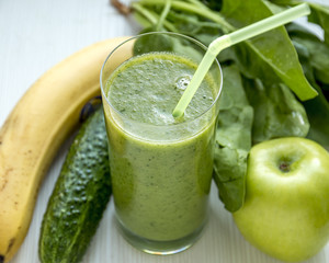 Glass of Green Smoothie with Plastic Tube. Green Healthy Cocktail with Ingredients - Spinach, Green Apple, Cucumber, Banana.
