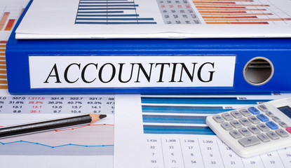 Accounting - blue binder in the office with calculator and pencil