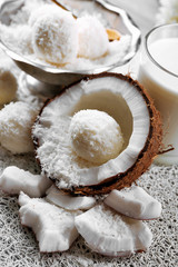 Homemade Candies in coconut flakes and fresh coconut on light background