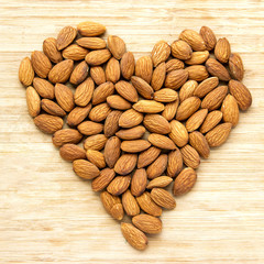 Heart of Almond Nuts over Wooden Background. Healthy Food Concept.