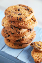 Cookies with chocolate crumbs on blue wooden table against blurred background, close up