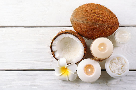 Spa coconut products on light wooden background