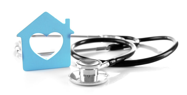 Concept of family medicine - blue plastic house with heart shaped window and stethoscope isolated on white background