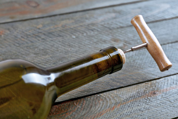 Obraz na płótnie Canvas Bottle of wine with corkscrew on wooden background