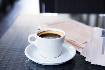 Cup of tasty coffee and newspapers in cafe