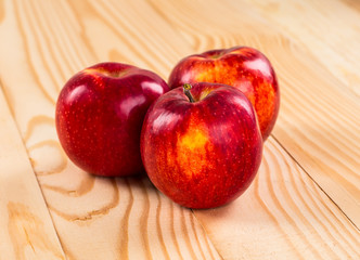 Ripe red apples on wooden background