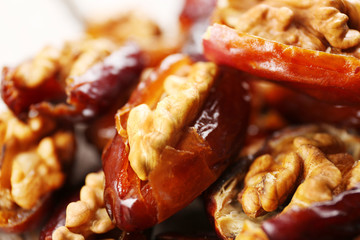 Walnut and date fruit on wooden table, close-up