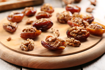Walnut, date fruit on wooden table, close-up