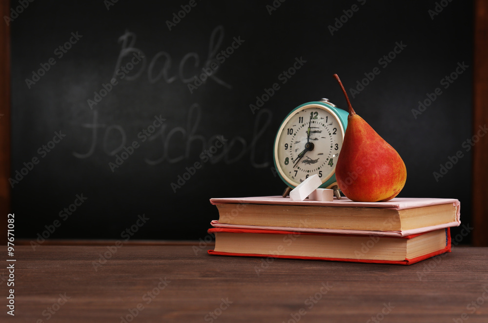 Wall mural pear and clock with books on desk background