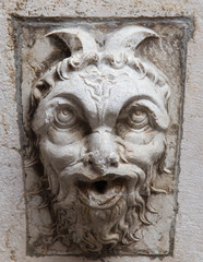 decoration of an ancient building in Italy of a demon in stone