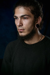 Fototapeta premium brutal young man with a beard against a dark background