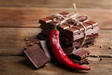 Black chocolate pieces with pepper on wooden background