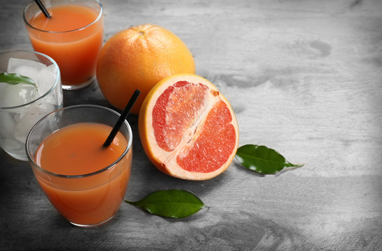 Citrus juice with ice and fresh fruits on wooden background
