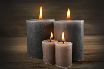 Fototapeta na wymiar Alight wax grey candle on wooden background