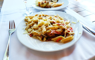 Pasta with cheese and sausage in a plate on the table