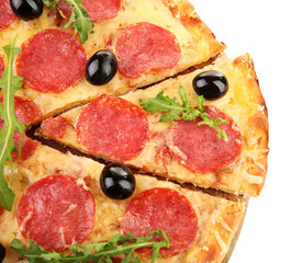 Cut pepperoni pizza with lives and arugula, isolated on white
