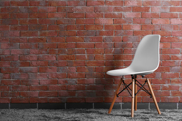 White modern chair on brick wall background