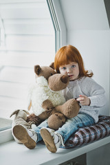 Girl with a toy sitting on the windowsill 4392.