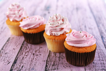 Tasty cupcakes on color wooden background