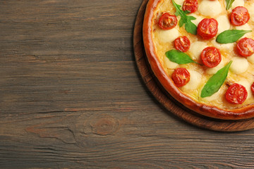 Pizza Margherita with arugula on wooden background