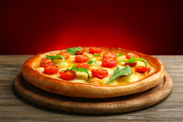 Pizza Margherita with arugula on dark red background