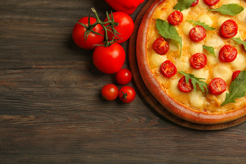Pizza Margherita with arugula, tomatoes   wooden table
