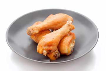 fried chicken thighs in dark porcelain dish