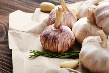 Composition of garlic and rosemary on the paper, close up