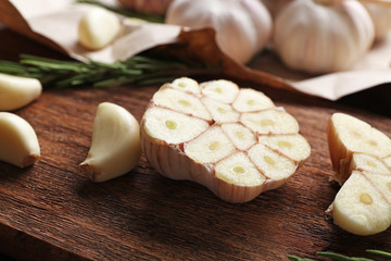 Composition of garlic and rosemary on the kitchen board, close up