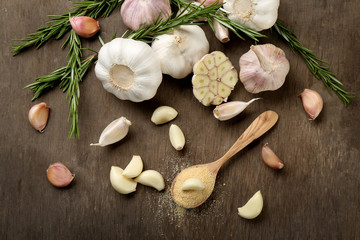 Composition of garlic and rosemary on wooden background