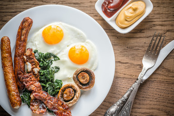 Fried eggs with bacon on the wooden table