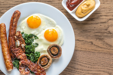 Fried eggs with bacon on the wooden table
