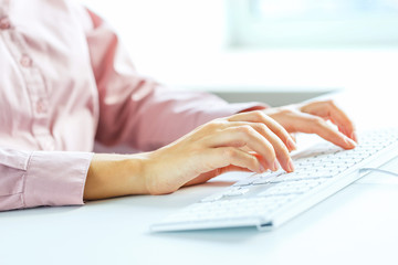 Woman office worker typing on the keyboard