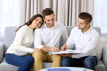 Estate agent meeting with happy couple, on light background