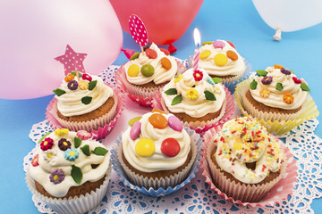 Birthday cupcakes with balloons on a blue background