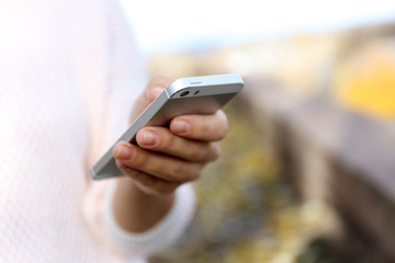 Woman holding smartphone outside