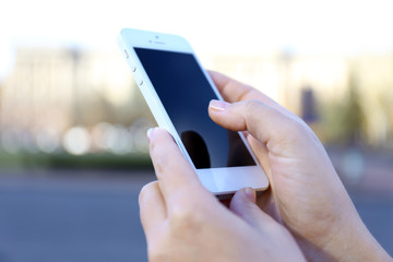 Woman holding smartphone outside