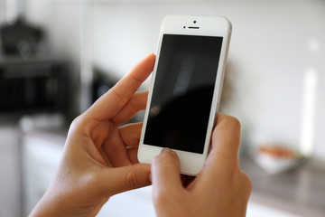 Woman holding smartphone indoors