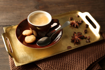Cup of coffee on tray, on wooden table background