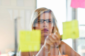 Shot through glass windows, a stylish blonde executive with glasses