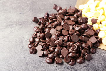 Dark and white chocolate morsels on gray background