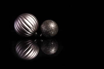Silver christmas ball ornaments and reflection on a black background
