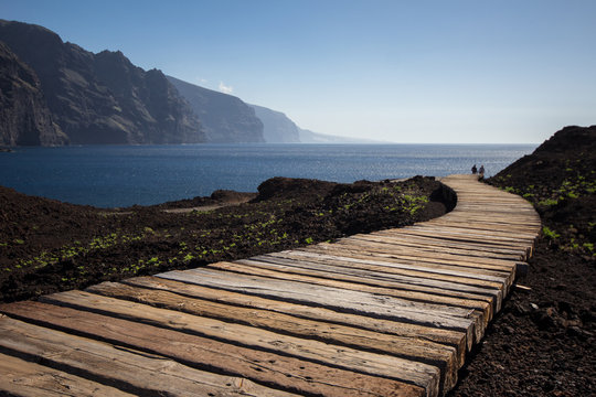 two friends / couple walking on wooden path to beach / ocean - Powered by Adobe
