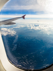 Clouds and sky as seen through window of an aircraft