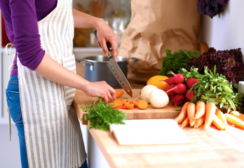 Young woman cutting vegetables in the kitchen