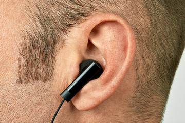 Ear with earphone closeup