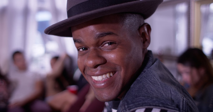 Portrait of Handsome young black hipster man smiling at party