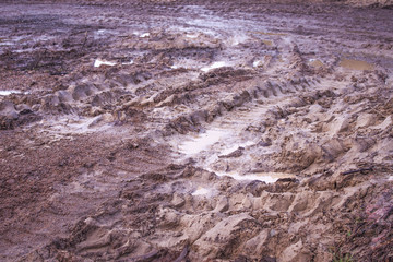 Tractor wheels muddy trails in clay